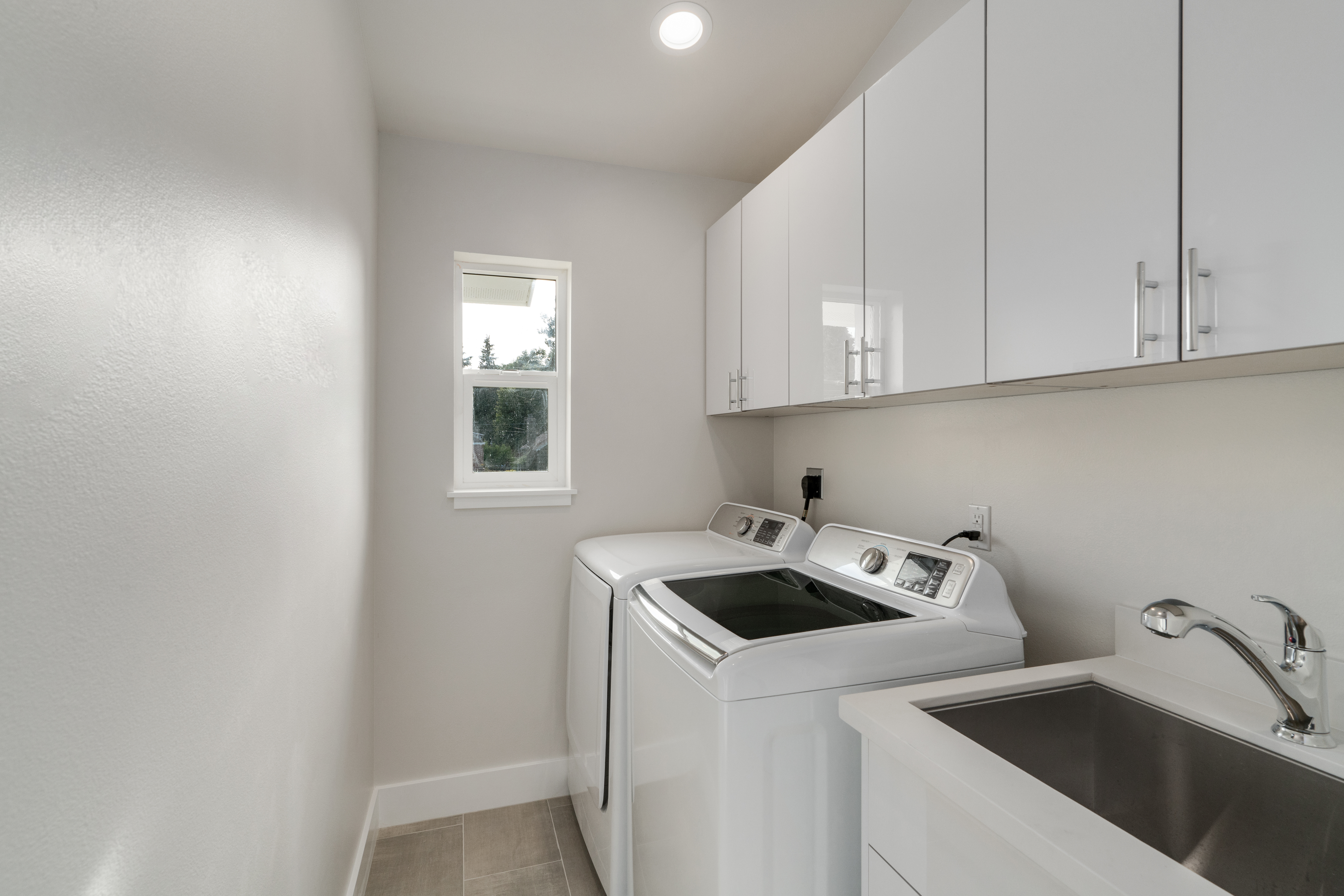 White laundry room features washer and dryer